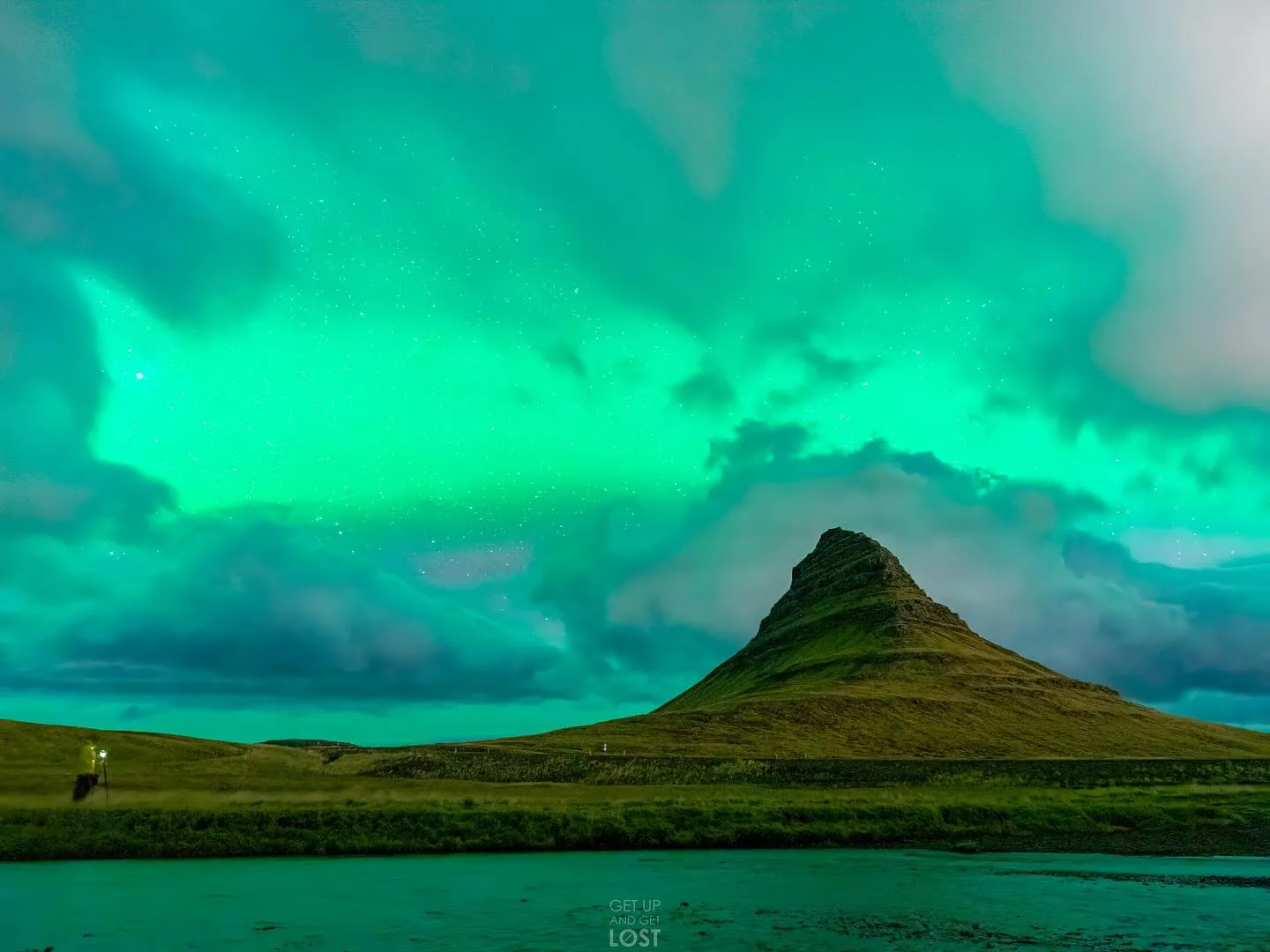 Green aurora borealis over a volcanic peak in Iceland.